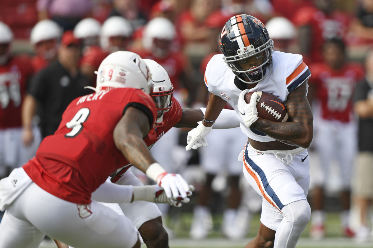 Virginia Cavaliers wide receiver Dontayvion Wicks (3) runs the ball against Louisville Cardinals linebacker C.J. Avery (9) during the first quarter at Cardinal Stadium.